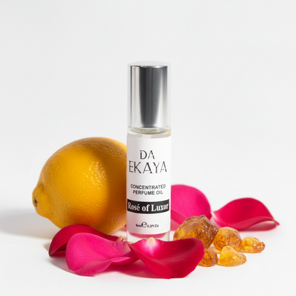 DA EKAYA perfume bottle with lemon and rose petals on a white background